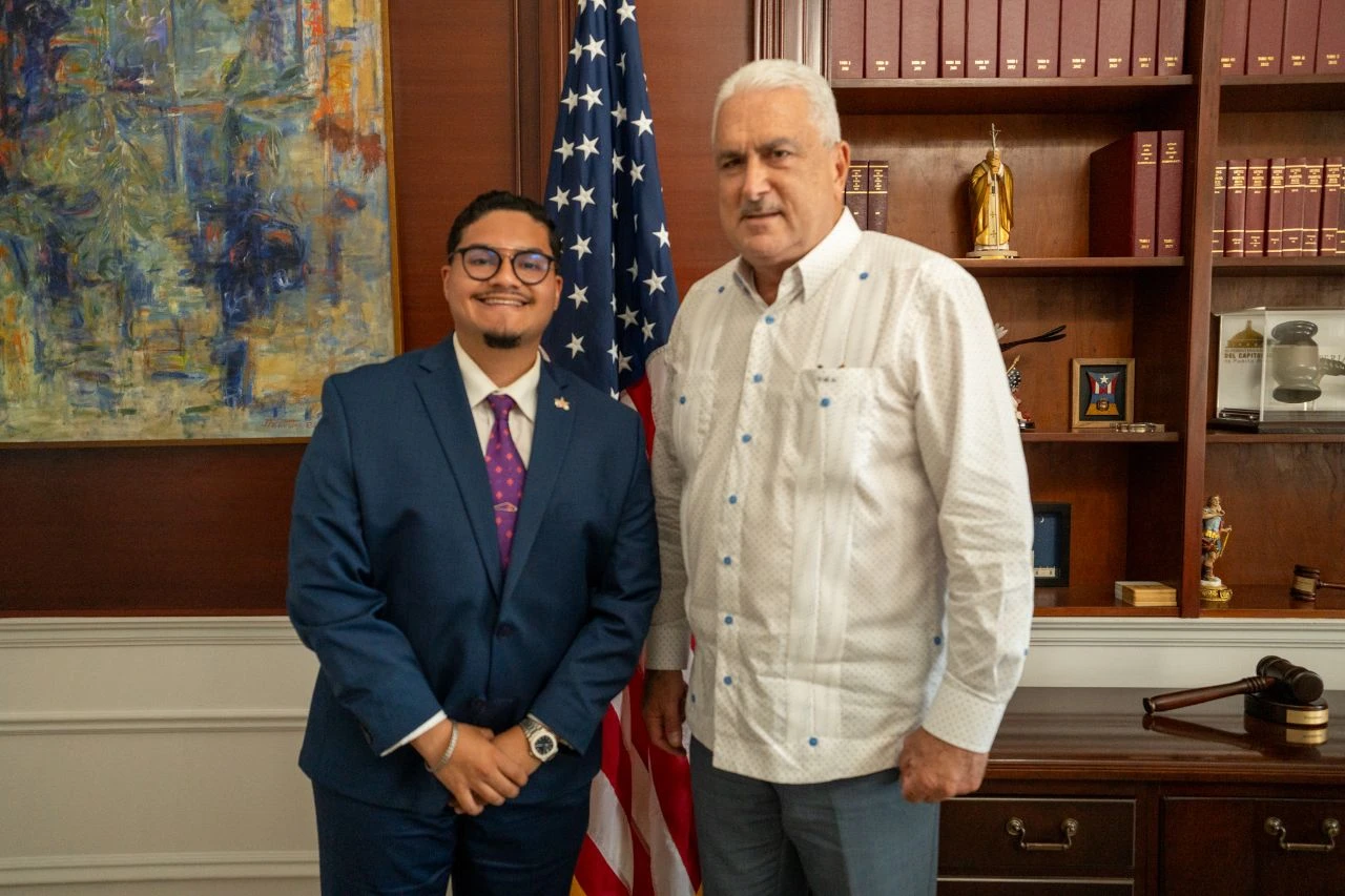  Ralyant Oxios y Thomas Rivera Schatz posan en la oficina del presidente del Senado en el Capitolio, frente a la bandera de Estados Unidos. Foto de INDIARIO.
