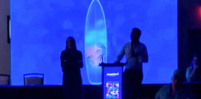 Imagen oscura muestra a dos oradores en el escenario de la convención del PNP en San Juan, tras apagarse las luces de forma accidental durante el evento.