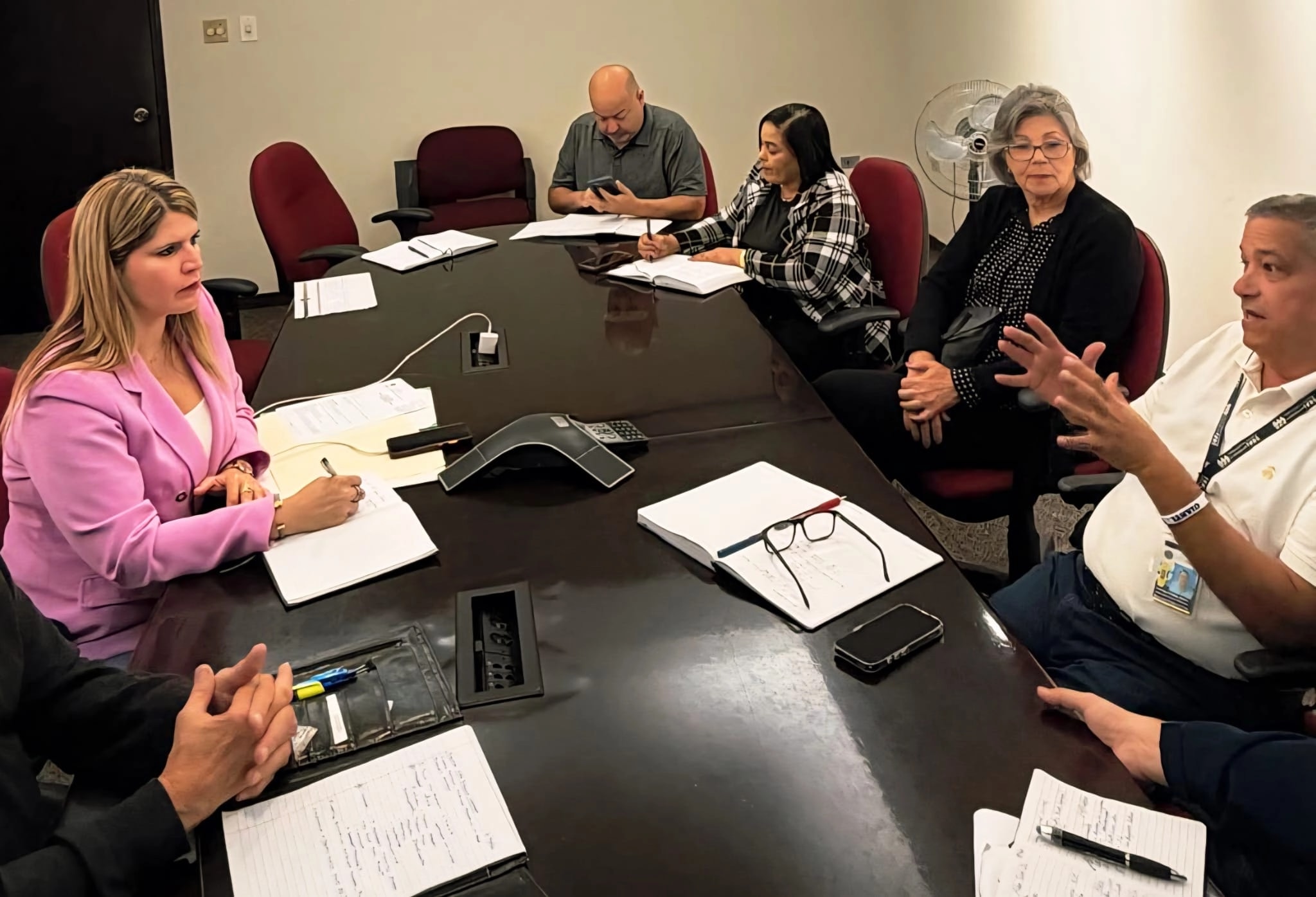 Grupo de funcionarios y empleados se reúnen alrededor de una mesa de conferencias mientras toman notas y discuten temas operacionales relacionados con el servicio de agua. (Imagen suministrada)